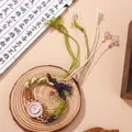 Detail of beaded quartz watch featuring ethnic braided strap and rose gold rhinestone dial - White
