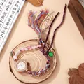 Close-up of bohemian woven bracelet watch with crystal bezel and colorful beads - White