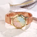 Close-up of rose gold watch featuring a rainbow gradient dial and elastic metal band - Rose Gold