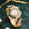 Close-up of luxury gold quartz watch with emerald crystals and rhinestone bezel details - Green Zircon