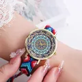 Makroansicht einer Uhr mit handgewebtem Armband und buntem Mandala-Muster auf Zifferblatt - Stil G