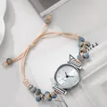 Detalle de correa de reloj con cuentas de mármol y dijes de metal plateado estilo retro - Azul claro