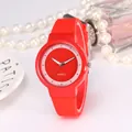 Detail of red minimalist quartz watch with silicone strap next to pearls on white background - Red