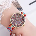 Detailopname van een boho quartz horloge met geweven band en mandala patroon wijzerplaat - Stijl K