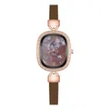 Detailed macro view of the rose gold oval case with crystal inlay and marble dial - Shell Roman Brown