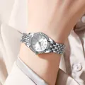 Primer plano de un reloj plateado para mujer con bisel de diamantes y esfera floral azul - Plateado