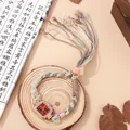 Macro-opname van boheems horloge met kralen, roségouden wijzerplaat en strass-franjes - Rood
