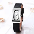 Macro shot of rectangular silver quartz watch with oval dial and black leather strap - Silver Case White Dial Black Strap