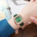 Detail of a square rose gold watch with a diamond bezel and green leather strap on wrist - Green Gold