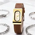Macro shot of vintage rectangular gold watch with brown leather strap and jewelry details - Gold Case Gold Dial Brown Strap