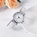 Detalle de elegante reloj de cuarzo para mujer con correa blanca de cuero sobre libro - Números Arábigos Blanco