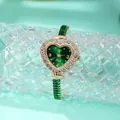 Macro view of heart-shaped quartz watch featuring a green dial and rhinestone bezel - Gold Green