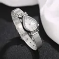 Macro-detail van druppelvormig horloge met kristallen bezel en zilveren mesh-band - Romeins Wit