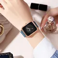 Detail of square rose gold quartz watch with dark green leather strap on female wrist - Black Dial Green Strap