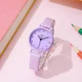Gros plan de la montre Tadi violette avec aiguilles coeur sur fond de papeterie rose - Ceinture violette