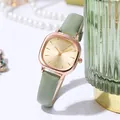 Detail of rose gold square watch case with gold dial and green leather strap in lifestyle setting - Light Green