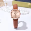 Macro detail of rose gold watch face with sunray dial and brown leather strap - Tan
