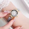 Gedetailleerde close-up van een dameskwartshorloge met diamanten bezel en grijze leren band - Grijs