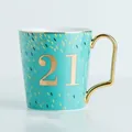 Tazza in ceramica celeste con numero 21 dorato e manico con finitura metallica - Young 21