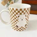 Ceramic mug featuring a brown checkerboard pattern and a cute white bear illustration - Brown White Checkerboard Bear