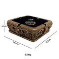 Detail of vintage gold square ashtray with ornate rose reliefs and metallic texture - Square