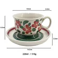 Hand-painted floral ceramic coffee cup and saucer set with red and green accents - Green
