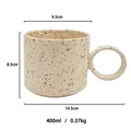 Handmade ceramic coffee mug with brown ink splash pattern and large round handle - Beige