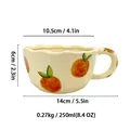Handmade ceramic coffee mug with orange fruit pattern and wavy rim showing dimensions - C Orange Style