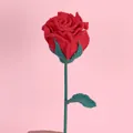 Rosa de ganchillo roja hecha a mano con hojas verdes sobre un fondo rosa suave - Rojo