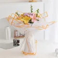 Handgefertigter Häkelblumenstrauß mit Lilien und Eukalyptusblättern in Geschenkpapier - Gelbe Lilie Stil