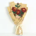 Bouquet de camélias rouges tricotés à la main dans un emballage papier vintage - Style rouge