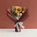 Makro-Detail eines handgehäkelten Sonnenblumenstraußes mit kleinen Gänseblümchen im Vintage-Papier - Braun