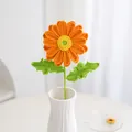 Handgehaakte oranje gerbera bloem met groene steel in een witte keramische vaas - Oranje