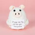 Detail of handmade crochet pig plush with a positive message card on pink background - Card Pig