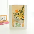 Detail of handmade crochet flower bouquet in white window box with a clover gift card - Yellow Series