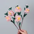 Handmade pink crochet camellia bouquet with green leaves and realistic knitted texture - Pink