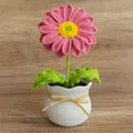 Handmade crochet pink daisy in a white textured ceramic pot with yellow raffia bow - Pink
