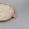 Détail d'une broche en émail en forme de renard sur un plateau en bambou tressé - Renard Enroulé (XZ0332)
