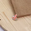 Détail de la broche renard en émail orange et blanc sur texture de bois clair - Xz0331