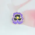 Détail d'une broche pensée en émail violet et jaune avec des bordures en métal doré - Xz0352