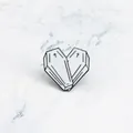 Vista macro del broche de corazón de ataúd de esmalte blanco con cruces en mármol - Estilo Corazón Ataúd / Blanco