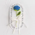 Detail of hand-crocheted blue rose with green leaf and Love Is Eternal ribbon - New Rose Crochet Flower (Blue Handbag) / Blue