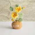 Handmade crochet yellow rose potted plant with green leaves on a white tabletop - Double Headed Rose Yellow