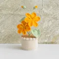 Detailed view of handmade crochet potted plant with two orange flowers and green leaves - Tung Flower Orange
