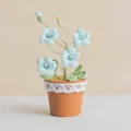 Handmade crochet potted blue flowers with delicate white lace trim on a terracotta pot - Light Blue