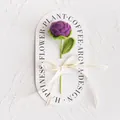 Detailed view of hand-knitted purple rose with leaves and Love Is Eternal ribbon - Dark Purple