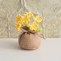 Detailansicht handgestrickter gelber Blumen in einem rustikalen braunen Jutesack - 6-Kopf gelbes Vergissmeinnicht-Stil