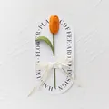Handgehäkelter orangefarbener Tulpenstrauß mit grünem Stiel auf weißer Geschenkarte - Orange