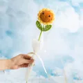 Handmade crochet sunflower bouquet with a smiling face against a clear blue sky - Smiley Sunflower