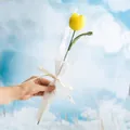 Single handmade crochet yellow tulip wrapped with LOVE IS ETERNAL ribbon against blue sky - Tulip Yellow